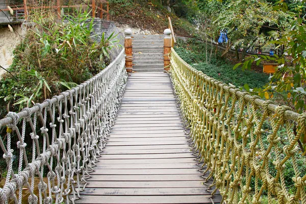 Puente colgante de cuerda de madera aventura en selva tropical —  Fotos de Stock
