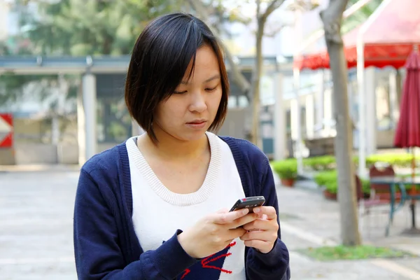 Mulher asiática mensagem de texto por telefone — Fotografia de Stock
