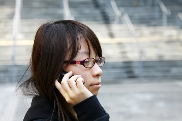 Asiatisk kvinna med mobiltelefon och talar — Stockfoto