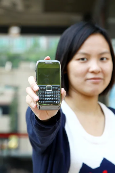 アジアの女性は彼女の携帯電話を示しています — ストック写真