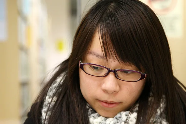 Asiatisk kvinna tänka och studera i biblioteket — Stockfoto