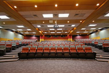 Colorful chairs in lecture hall of a university clipart