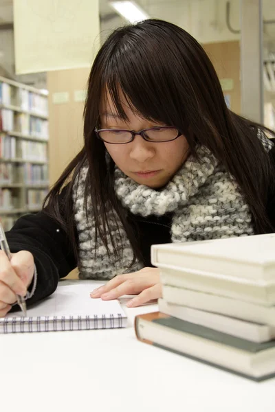 Asian university student in library — Stock Photo, Image