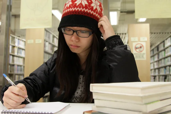 Mujer asiática estudiando en la biblioteca — Stockfoto
