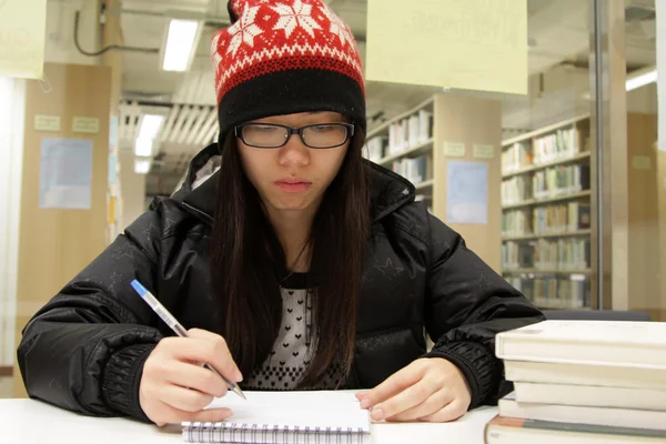 Asiatisk kvinna studera i biblioteket — Stockfoto