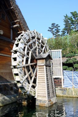 Water wheel next to a house clipart