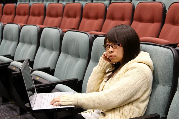 Студент из Азии учится в аудитории с ноутбуком — стоковое фото