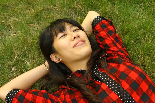 Aziatische vrouw slapen op het gras en zeer ontspannen — Stockfoto