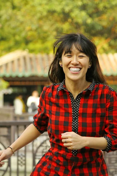 Asiatisk kvinna springer med leende — Stockfoto