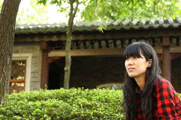 Китайская девочка думает на открытом воздухе — стоковое фото