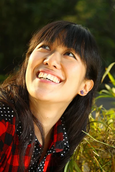 Азиатка улыбается под солнцем — стоковое фото