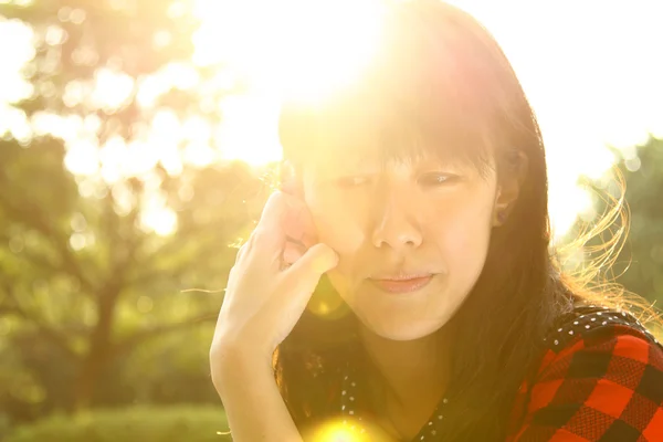 Ασιατική γυναίκα σκέφτεται κάτω από τον ήλιο — Φωτογραφία Αρχείου