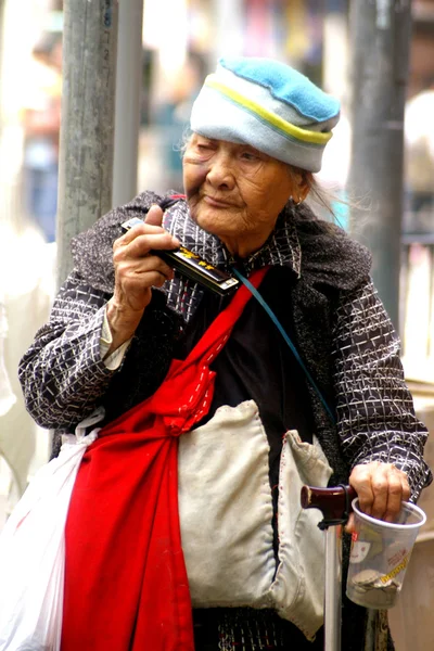 Alte Frau spielt auf der Straße in Hongkong Musik — Stockfoto