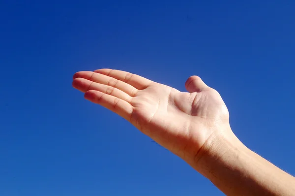 Ger hand under blå himmel — Stockfoto