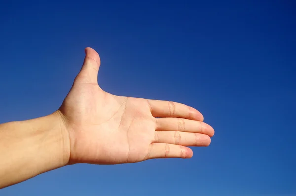 Hand geben unter blauem Himmel — Stockfoto