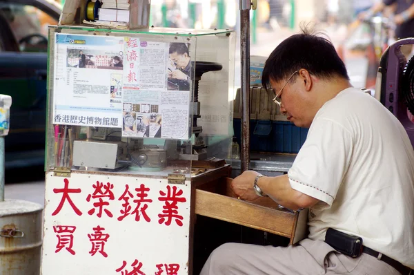 Um homem que se concentra em fazer relógio em Hong Kong — Fotografia de Stock