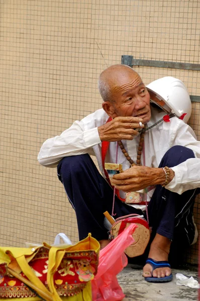 Een oude man roken langs de straat in hong kong — Stockfoto
