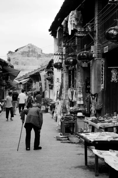 Uma velha caminhando ao longo da rua — Fotografia de Stock