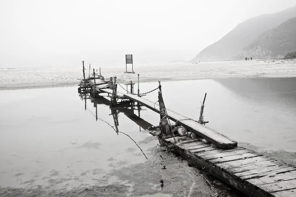 Опустошенный пирс рядом с морем — стоковое фото