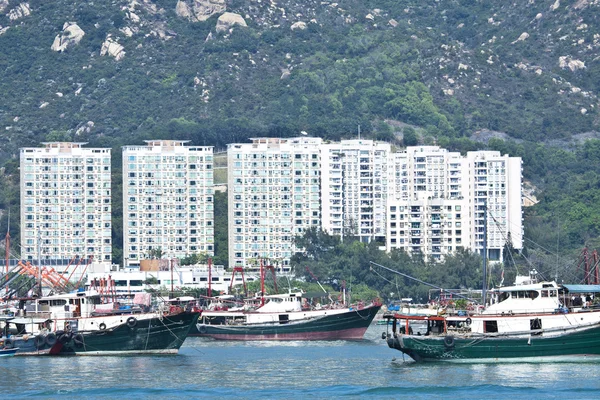 Barcos de pesca e blocos de apartamentos em Hong Kong — Fotografia de Stock