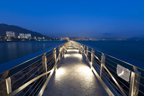 Puente pasarela a lo largo de la costa por la noche — Foto de Stock