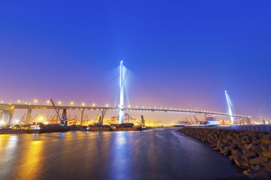 Hong Kong bridge at cargo terminal at night clipart