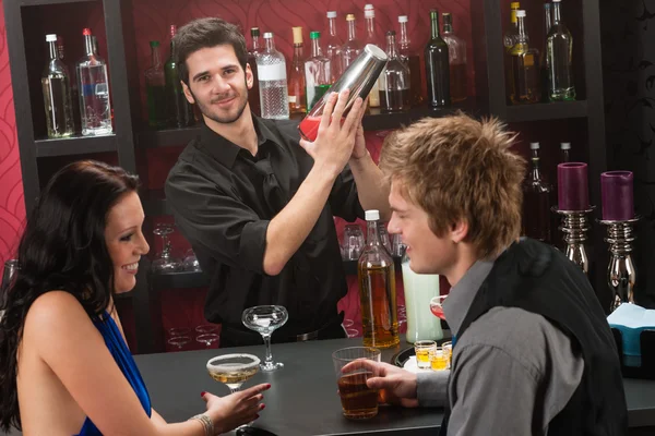 Bartender shaking cocktail friends having drink — Stock Photo, Image