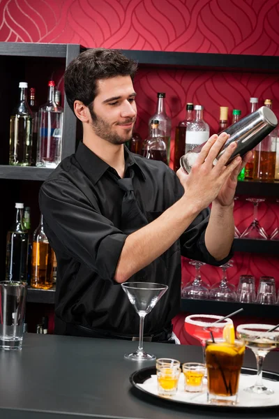 Giovane barista fare cocktail scuotendo bevande — Foto Stock