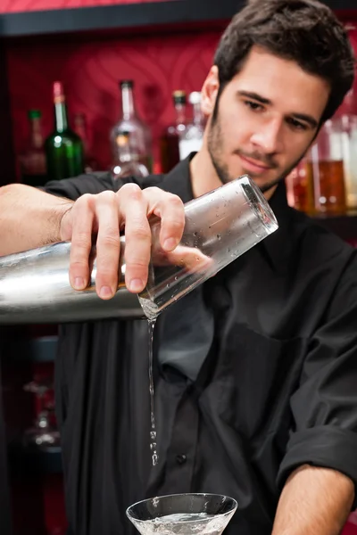 Jovem barman fazer coquetel agitando bebidas — Fotografia de Stock