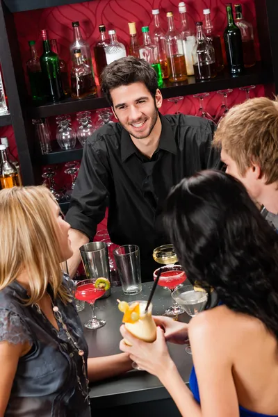 Бармен болтает с друзьями, пьющими в баре — стоковое фото