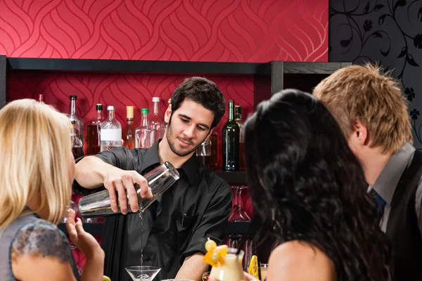 Бармен готовит коктейли друзьям пить в баре — стоковое фото
