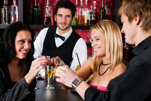 Barman atrás de contra-amigos bebendo no bar — Fotografia de Stock