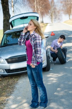 Woman calling for car assistance change wheel clipart