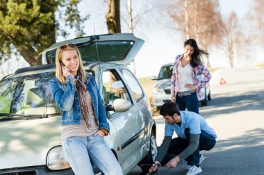 Broken wheel man helping two female friends clipart