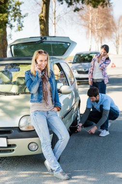 Wheel defect man helping two female friends clipart