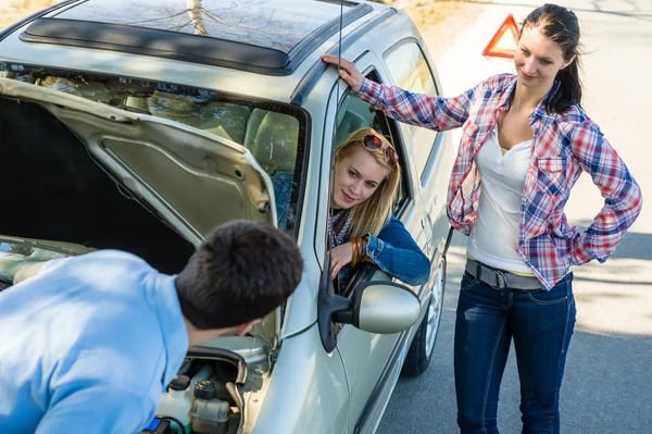 Человек с дефектом автомобиля помогает двум подругам — стоковое фото
