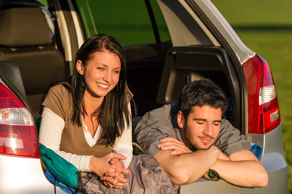Camping jovem casal deitado carro verão por do sol — Fotografia de Stock