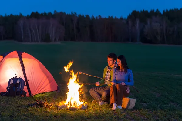 Camping nacht paar koken door kampvuur romantische — Stockfoto