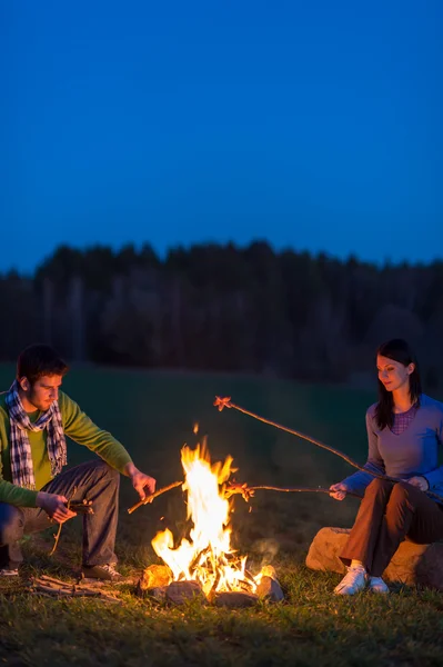 Couple cuisinier par feu de joie romantique nuit campagne — Photo