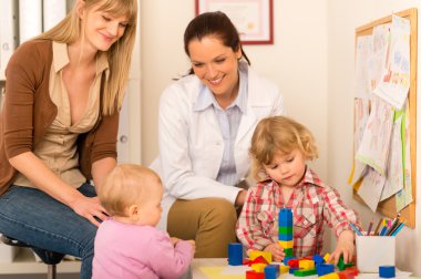 Pediatrician mother daughter playing at office clipart