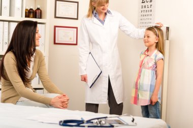 Medical check-up pediatrician girl measure height clipart