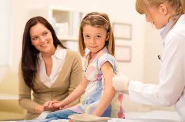 Pediatrician apply injection to little girl clipart