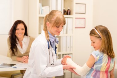 Pediatrician checking bandage girl arm clipart