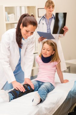 Pediatrician examining girl broken leg clipart