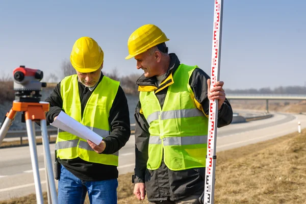 Geodesist 两个男人经纬仪站公路 — 图库照片