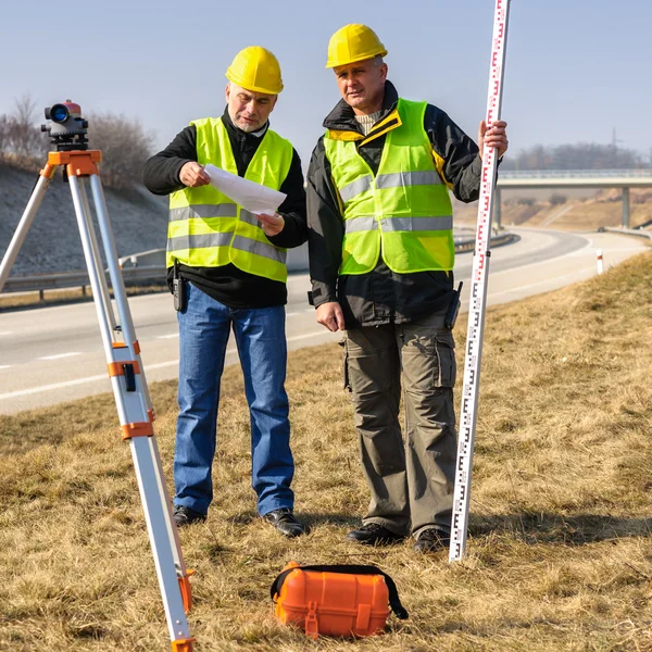 Geodesist iki adam teodolit stand Otoban — Stok fotoğraf