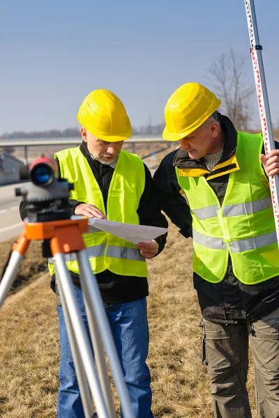 Geodesist due uomo theodolite stand autostrada — Foto Stock