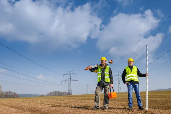 Geodeet twee man apparatuur op de bouwplaats — Stockfoto