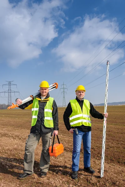 Geodesista equipo de dos hombres en el sitio de construcción — Foto de Stock