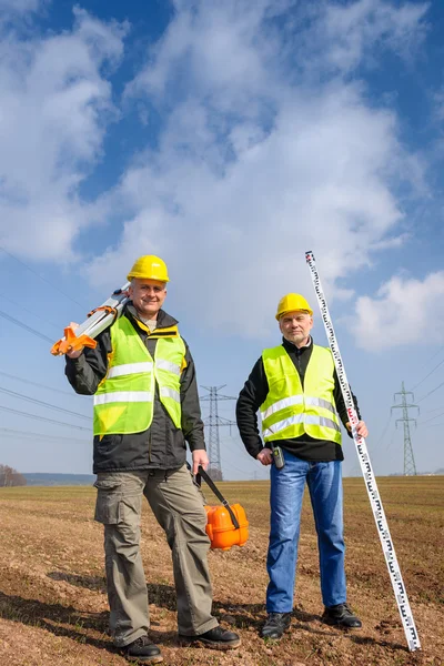 Geodesista equipo de dos hombres en el sitio de construcción — Foto de Stock